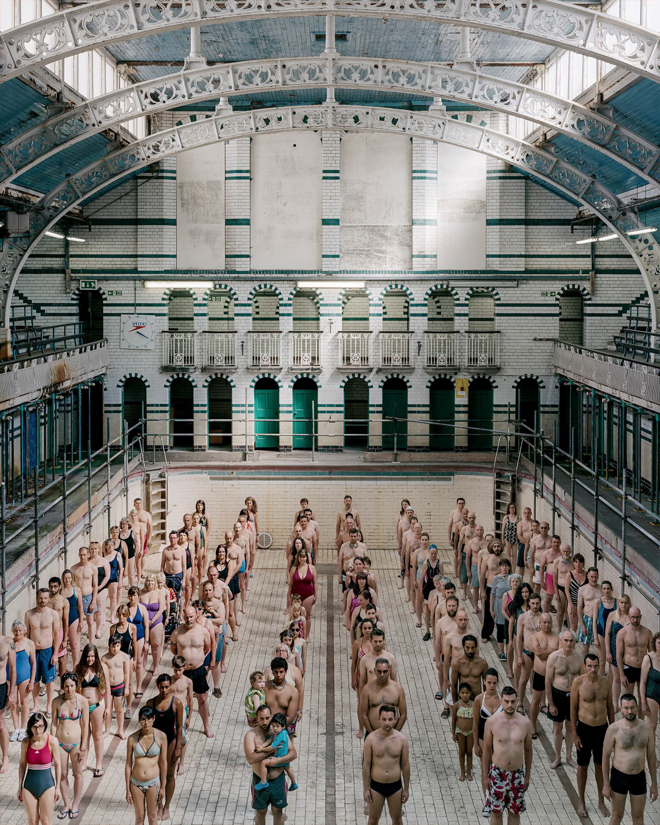 100 people standing in an empty pool.