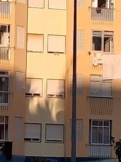 Crescent-shaped shadows on a building wall.