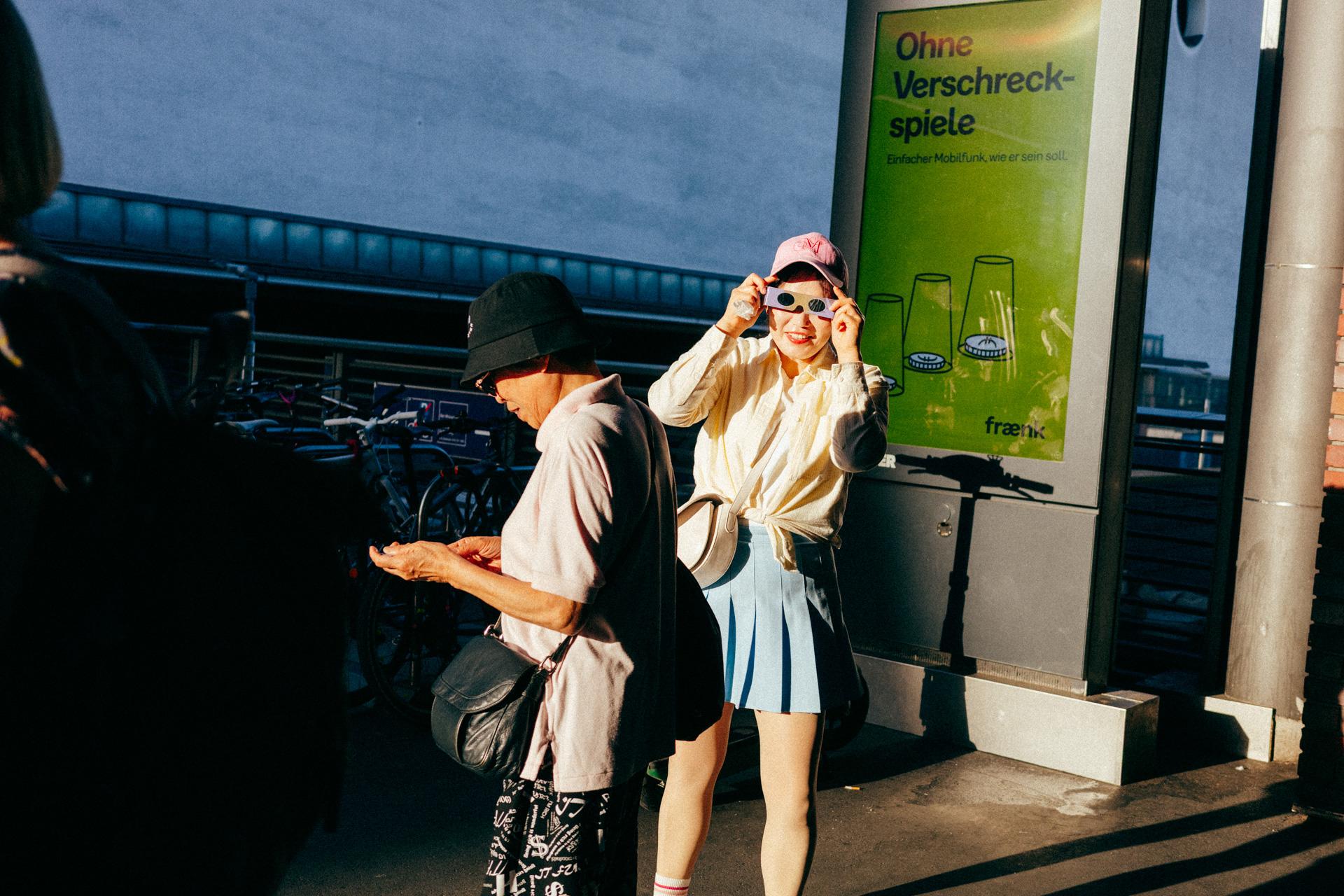 Dos personas con gafas para ver el eclipse en la estación de Gesundbrunnen.
Two people wearing eclipse-viewing glasses at Gesundbrunnen station.