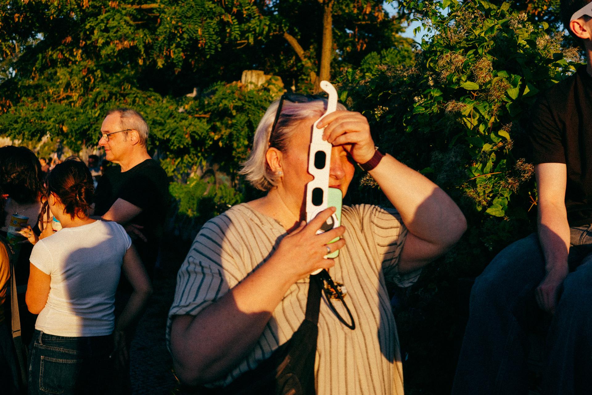 Persona mirando el eclipse con unas gafas de cartón.
Person watching the eclipse with cardboard glasses.