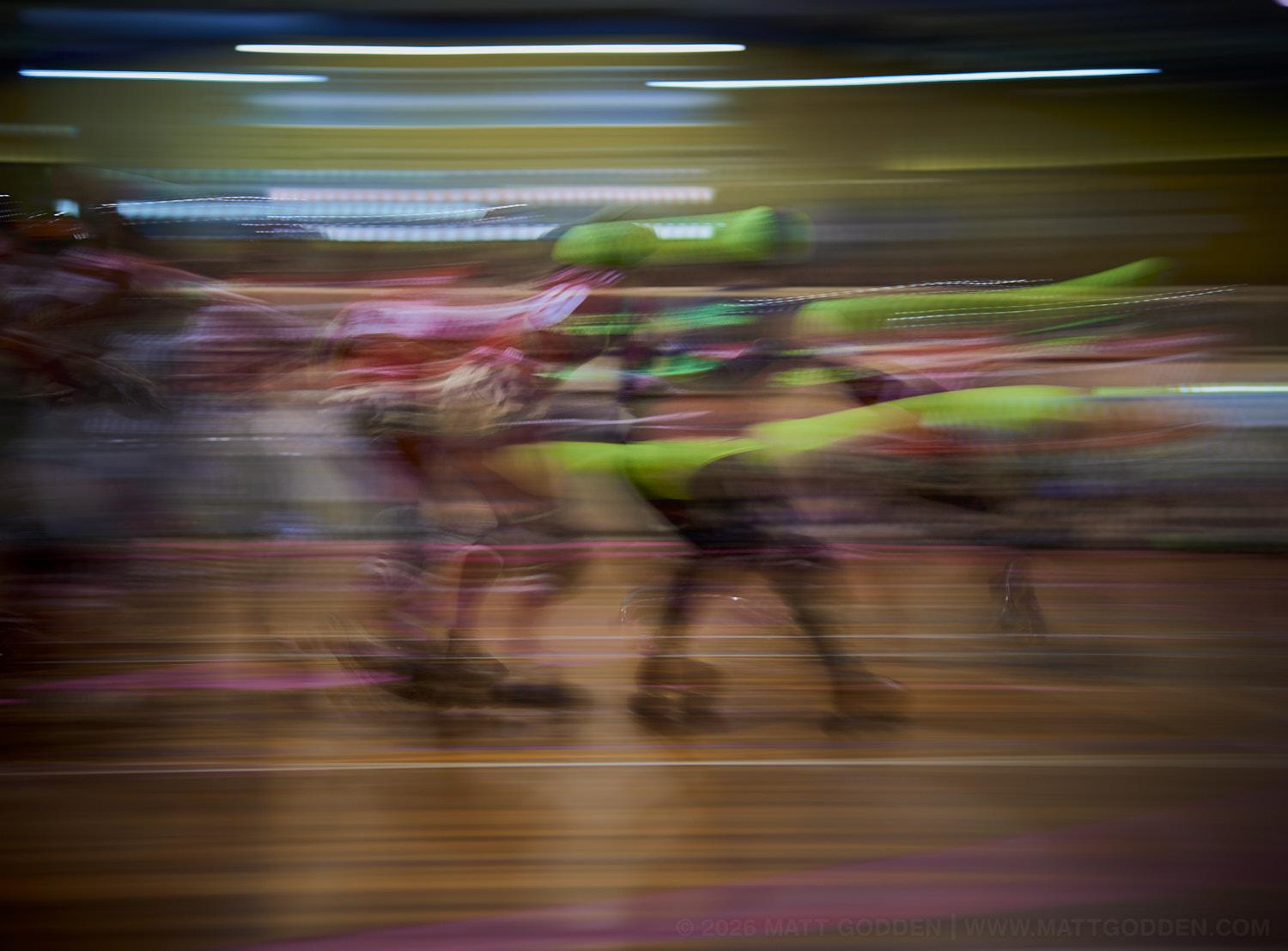 A long exposure image of roller derby competitors from the D'Viants (lime green), and the Screaming Assault Sirens (red). 2013/11/09
