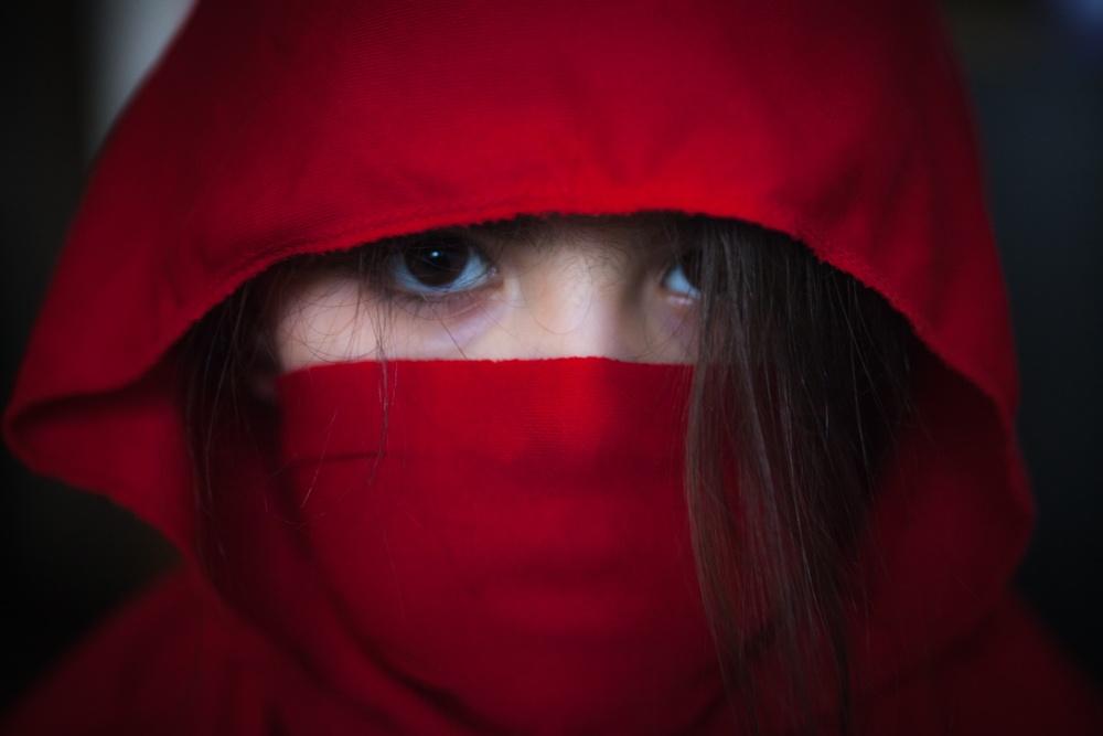Niña disfrazada de ninja rojo.