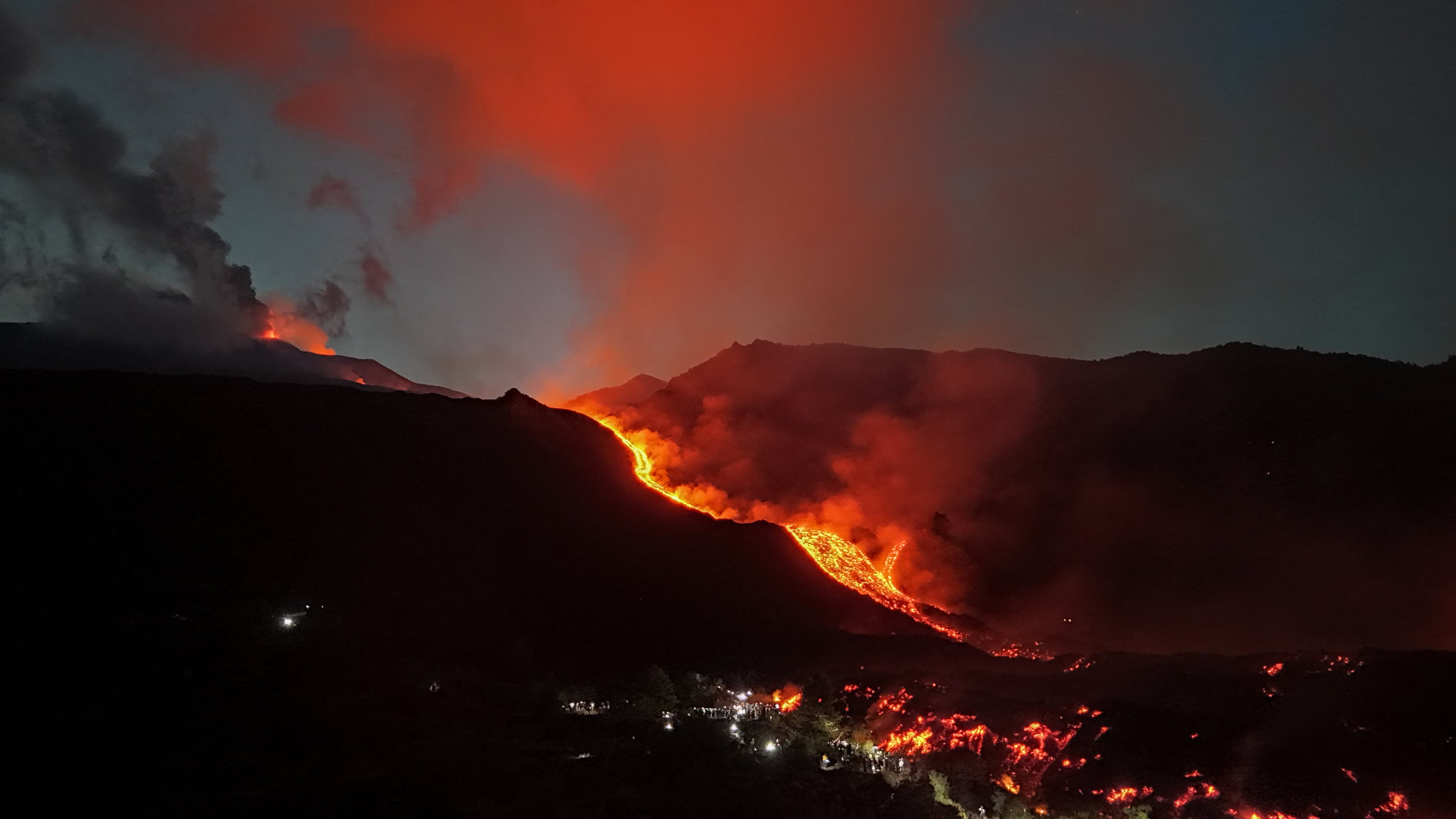 A drone shot shows volcanic ash and lava during an eruption of Mount Etna.