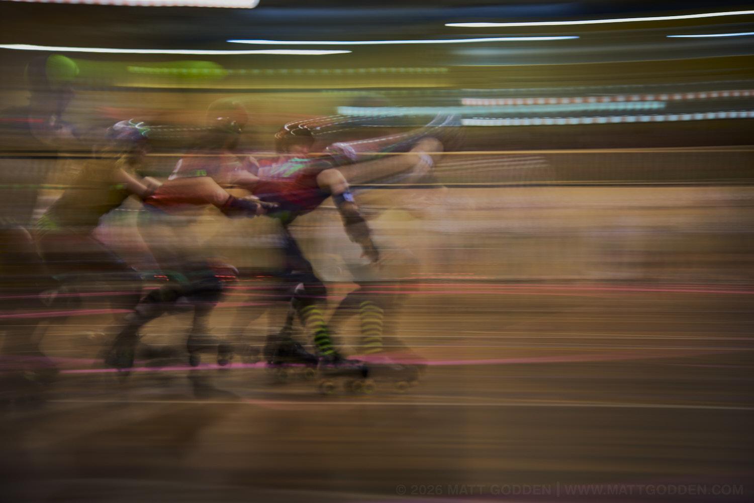 A long exposure image of roller derby competitors from the D'Viants (lime green), and the Screaming Assault Sirens (red). 2013/11/09