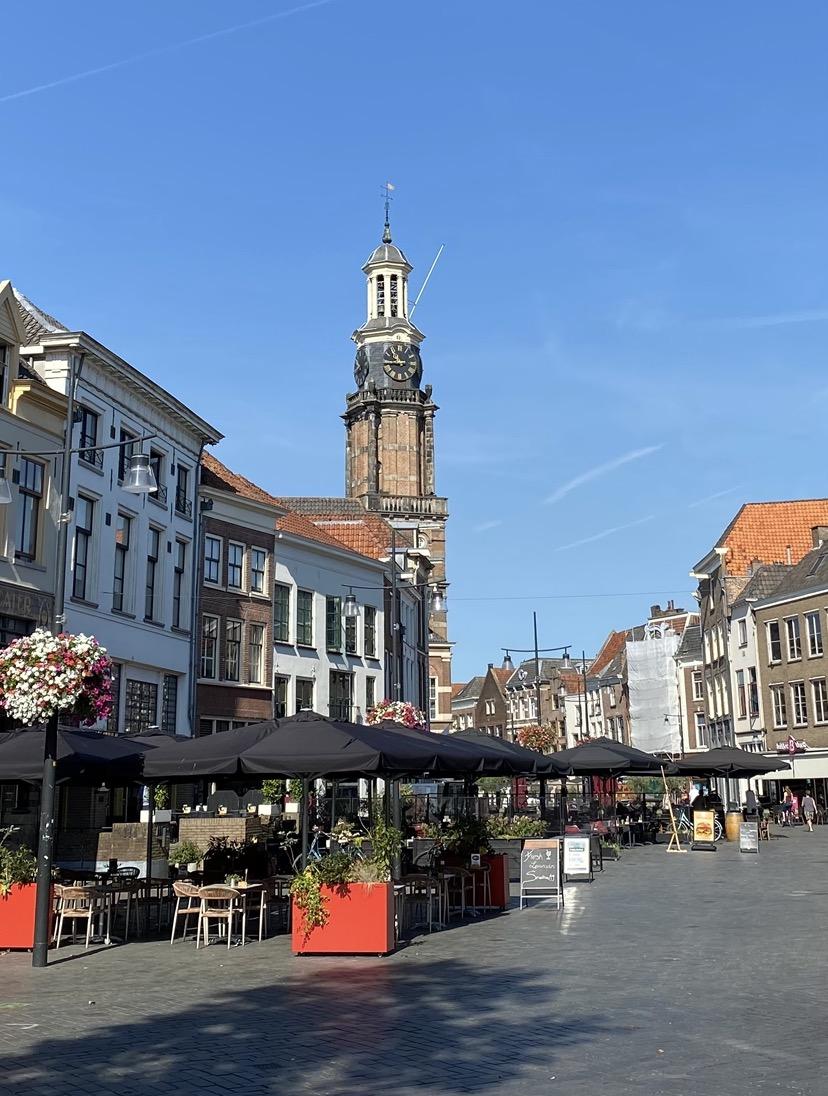 Straat met terrasjes en kerk op de achtergrond