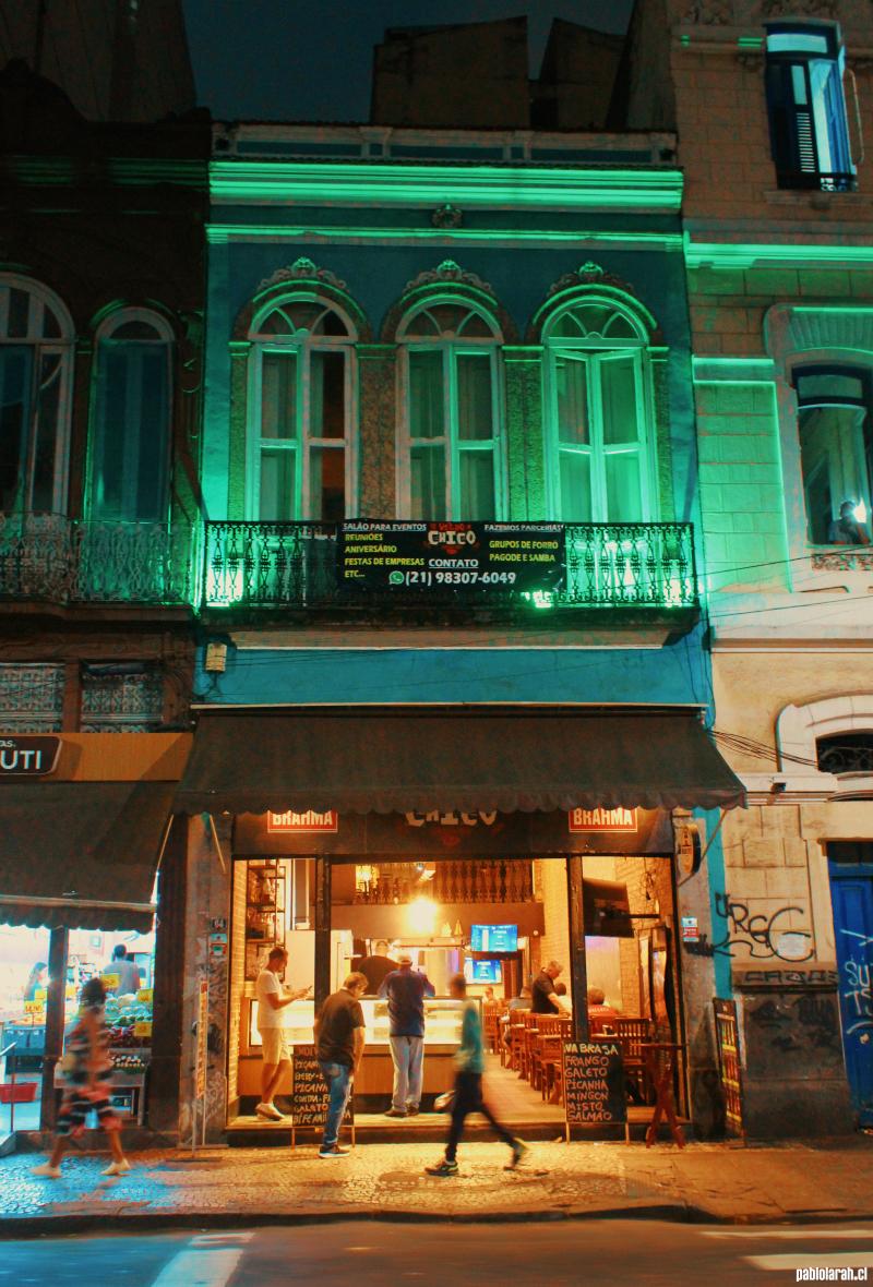 Tall two stories building by night at Lapa with illuminated restaurant in the first floor.