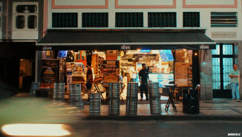 Restaurant in Lapa illuminated by the interior lights with big beer cans in the front