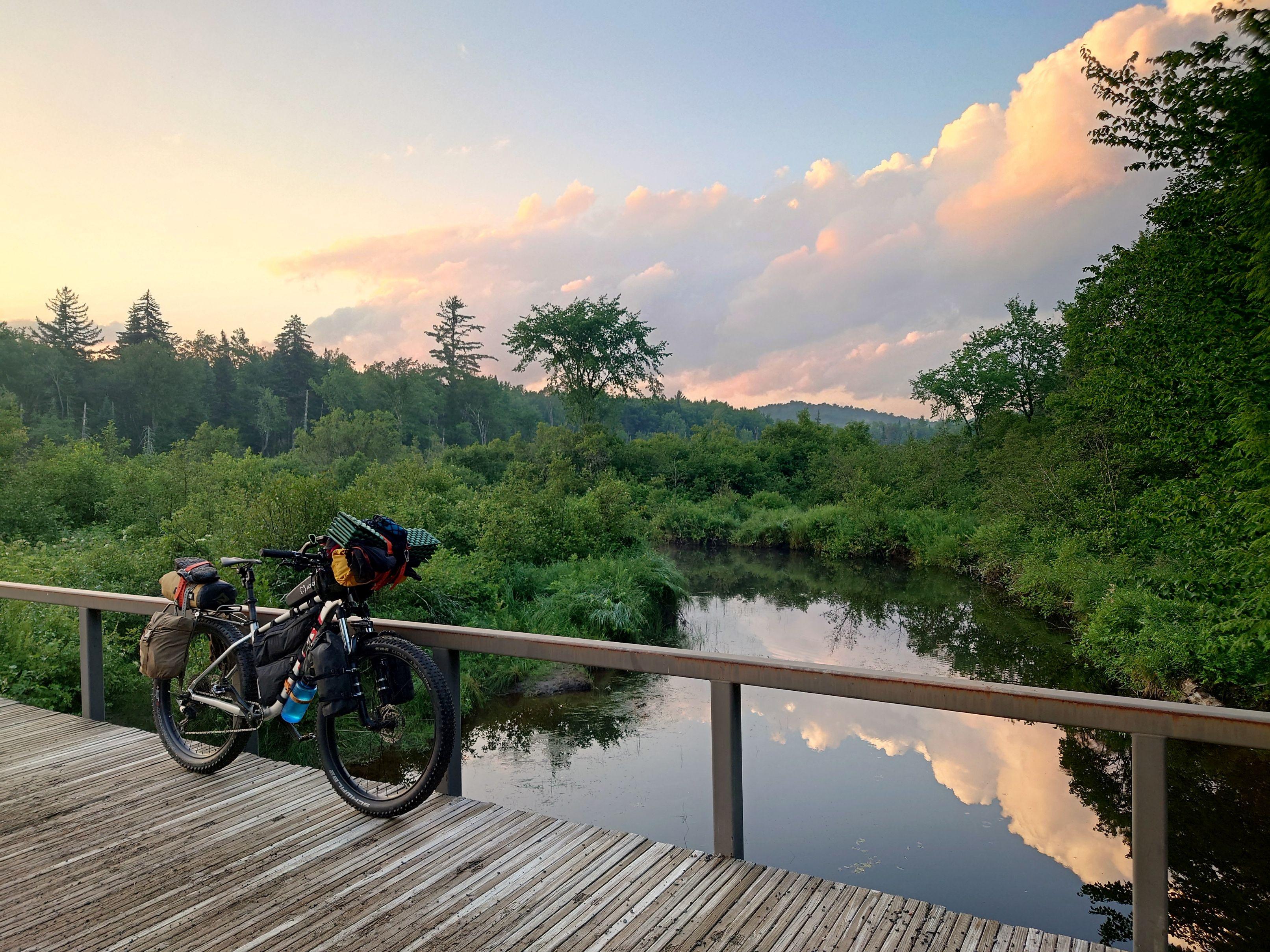 Loaded bikepacking bicycle on bridge over river in the Adirondacks