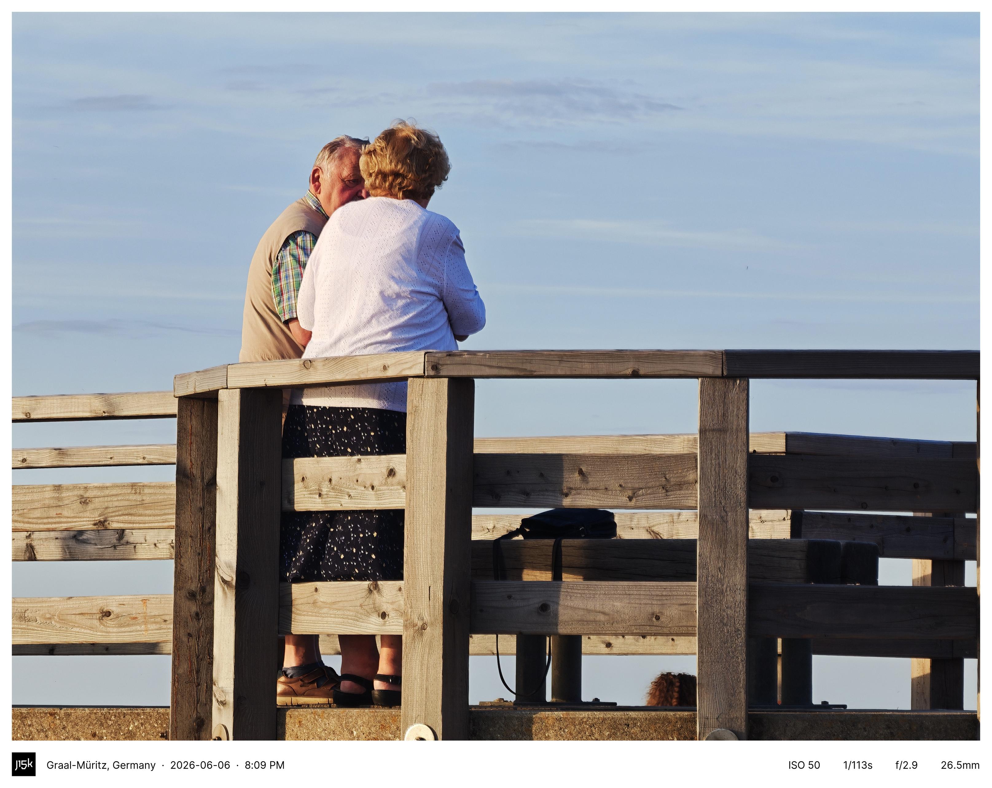 Photo of a retired couple on the pier in Graal-Müritz at sunset.