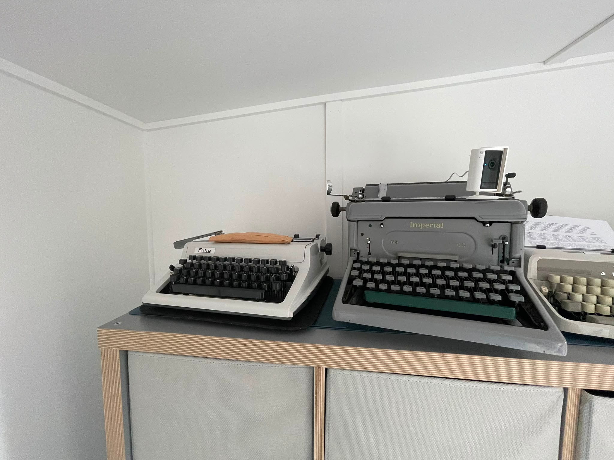 Close up of two typewriters on top of a storage unit.