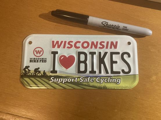 A small license plate that says “I ❤️bikes”, “Support Safe Cycling”, and “Wisconsin Bike Fed”.