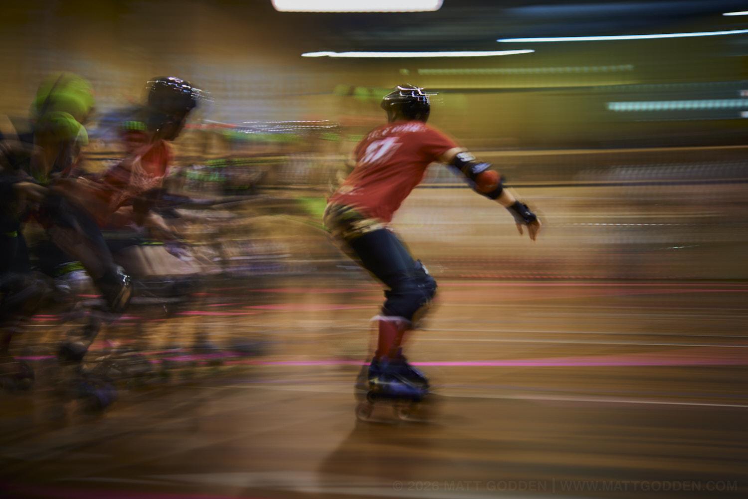 A long exposure image of roller derby competitors from the D'Viants (lime green), and the Screaming Assault Sirens (red). 2013/11/09