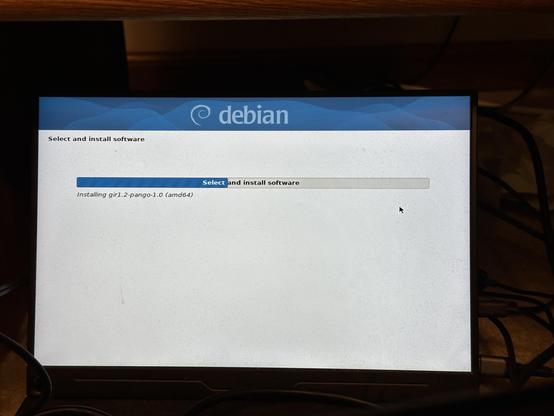 Photo of a monitor displaying the Debian graphical installer's progress bar