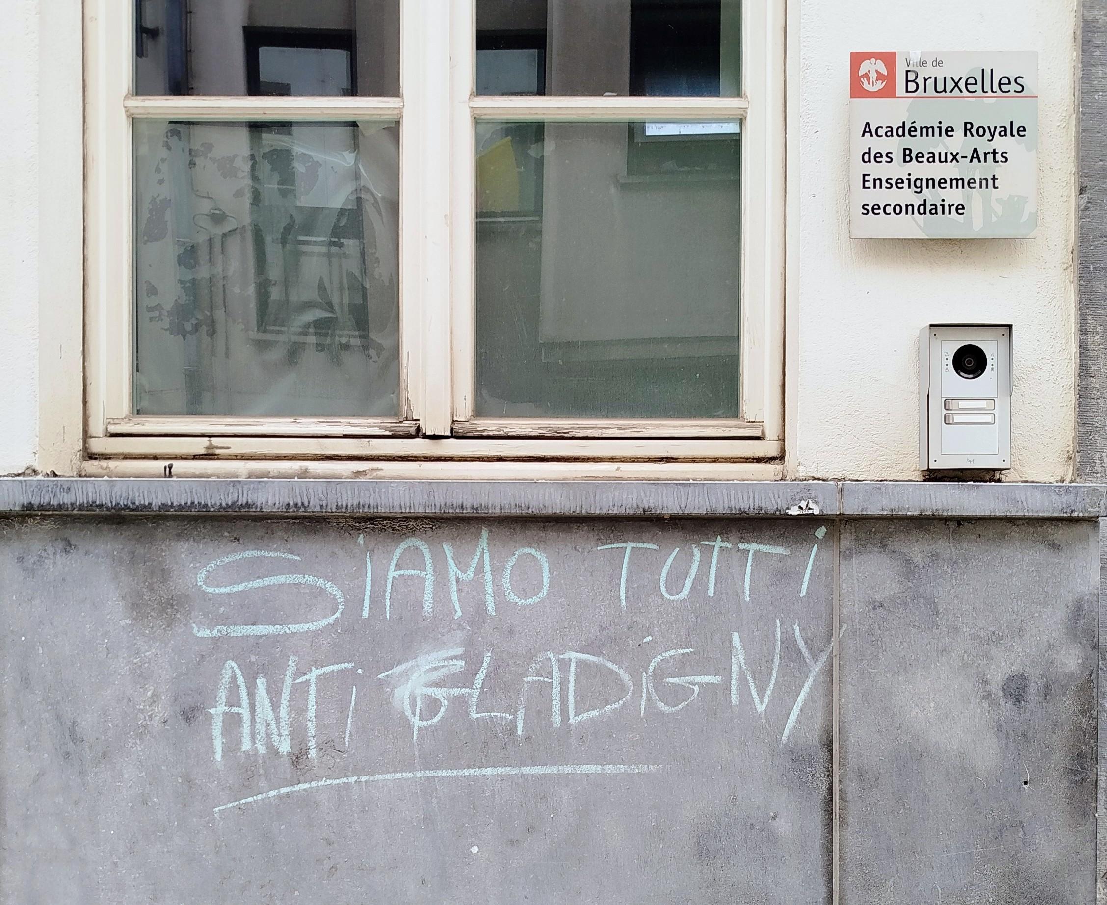 Photo de façade de bâtiment de l'Académie des Beaux-Arts.
Haut : fenêtre.
Bas : mur avec inscription à la craie :" siamo tutti anti-Glatigny"