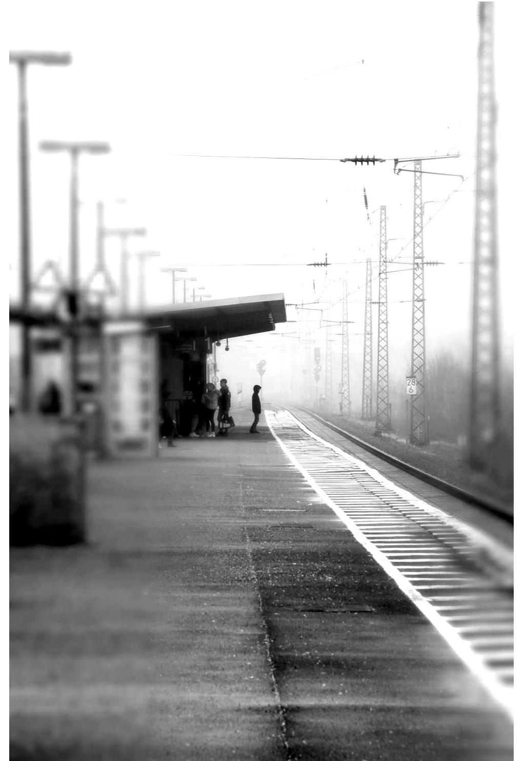 Ein Bahnsteig. In der Ferne steht ein Junge. Er wartet auf den Zug.