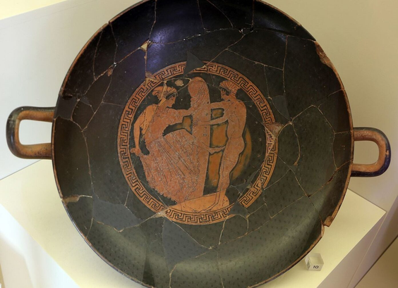 Red-figure vase painting of two women dancing around a woman-sized phallus.