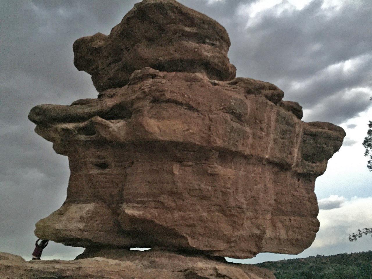 Photo by Fenichel: Balancing Rock (Garden of the Gods)

Here is an image offering some sense of scale and perspective.
The legendary rock, which sits on a precarious-looking base, is seen here with a tourist (lower left) striking a pose at its base, pretending to push it over.