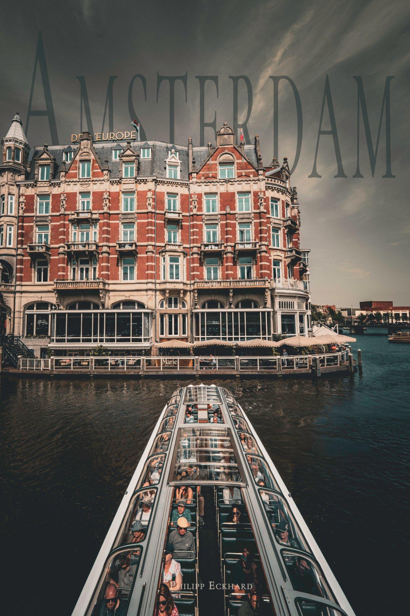 A Canal Boat steering away from Hotel De L'Europe in Amsterdam Gracht.