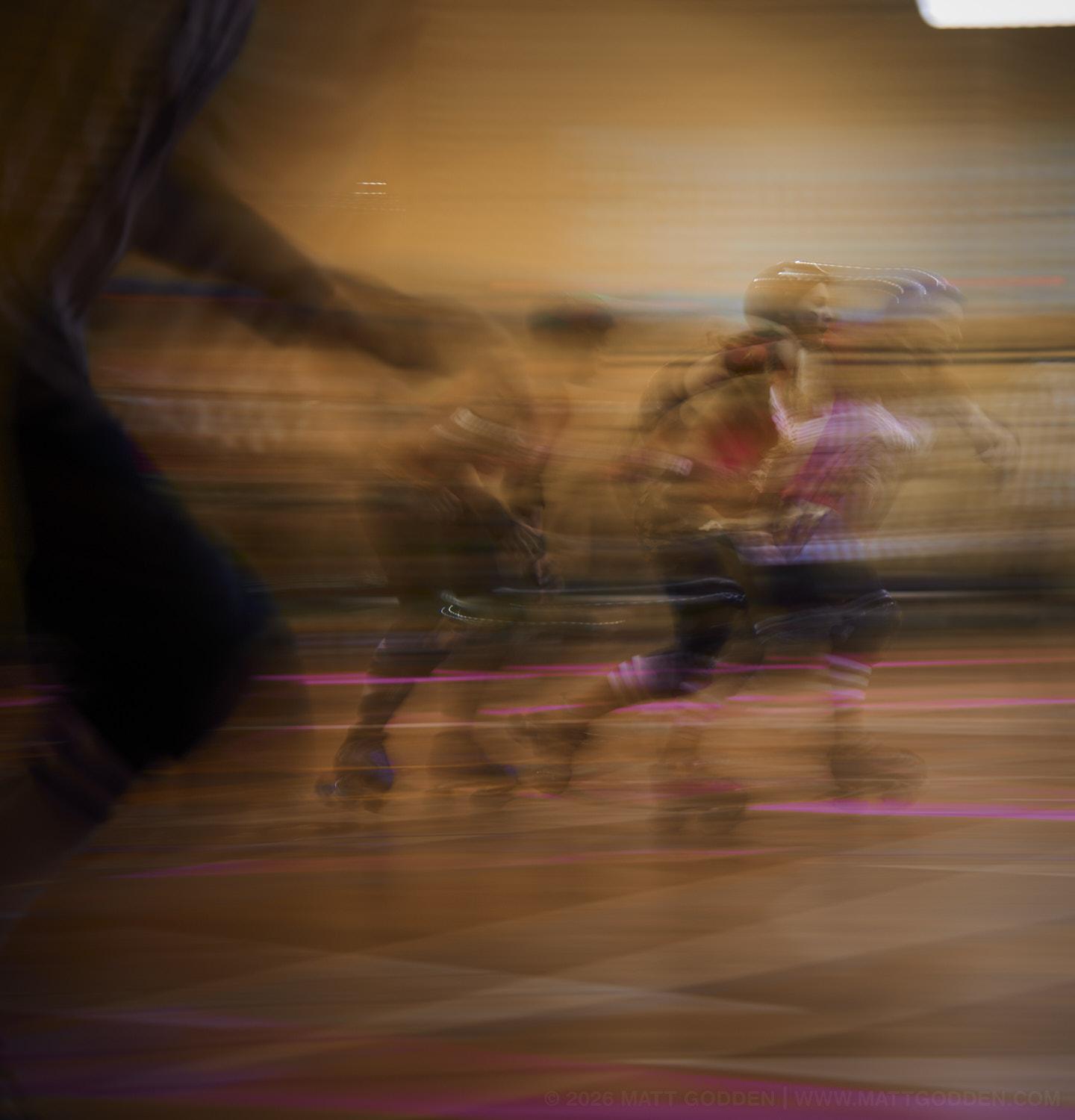 A long exposure image of roller derby competitors from the D'Viants (lime green), and the Screaming Assault Sirens (red). 2013/11/09