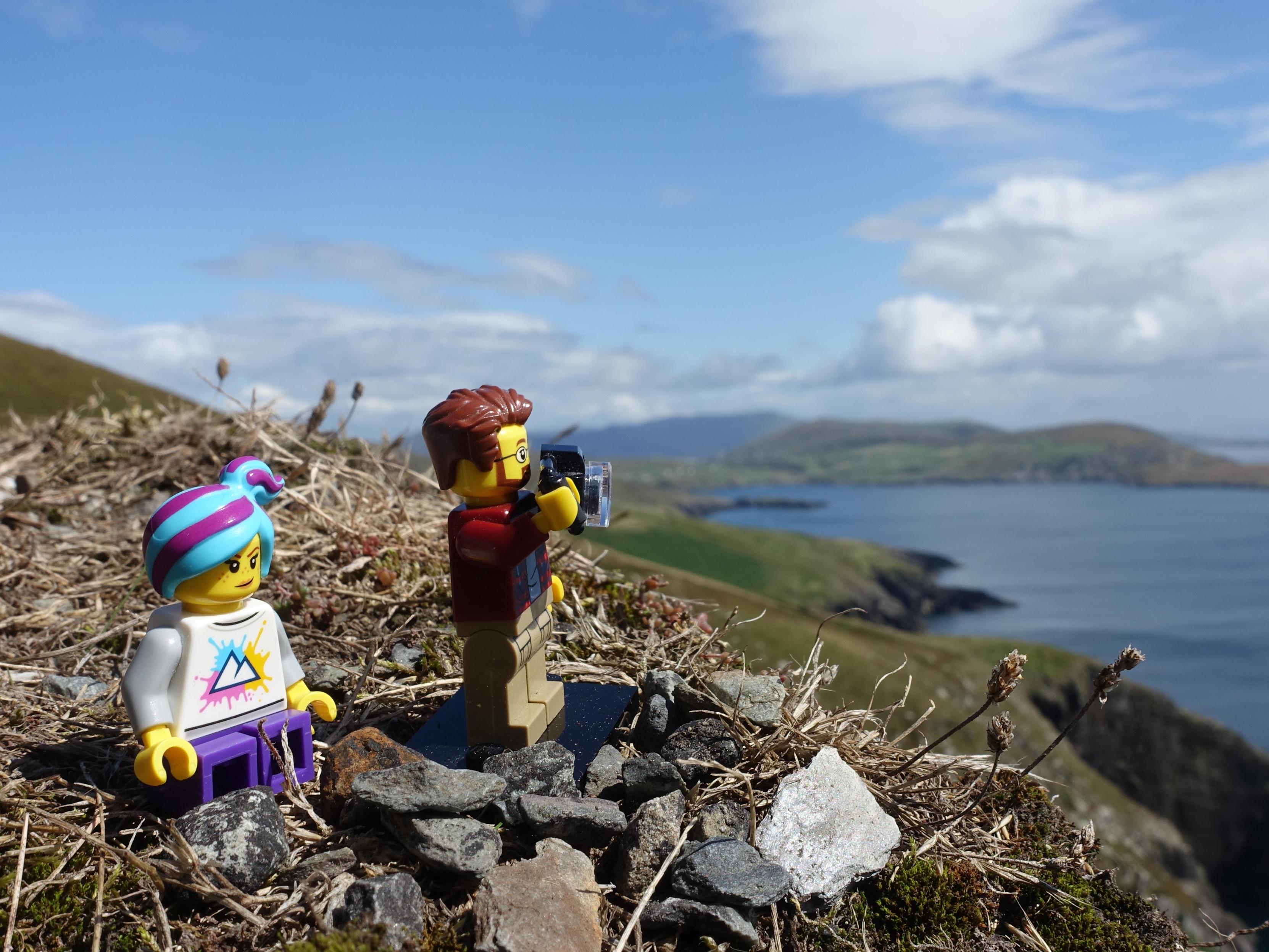 Two Lego minifigures, enjoying and taking pictures of the beautiful Irish coastline.
