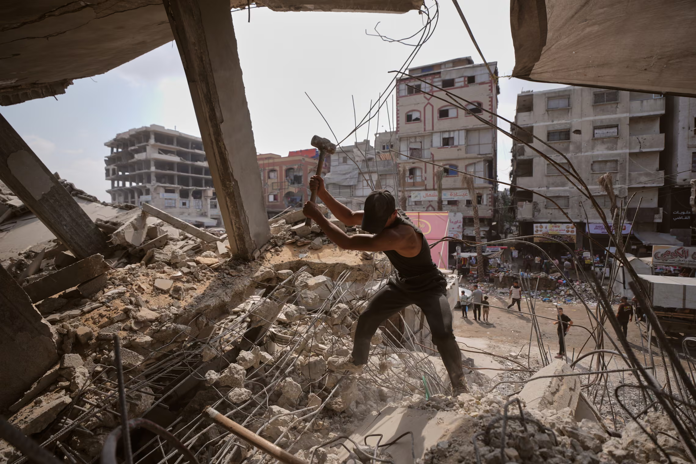 A man remove iron from the rubble of a building.