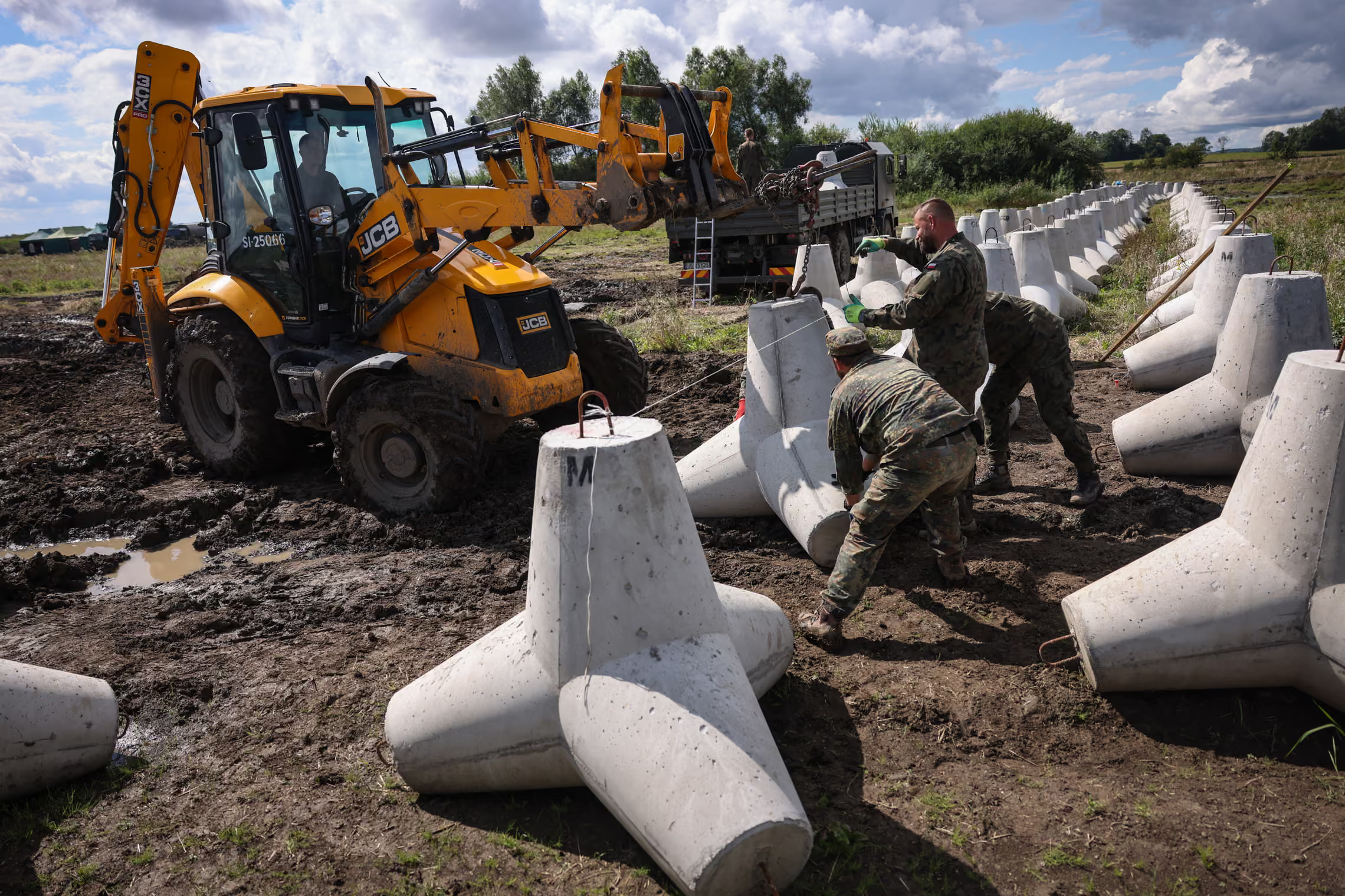 Soldiers  install concrete anti-tank obstacles.