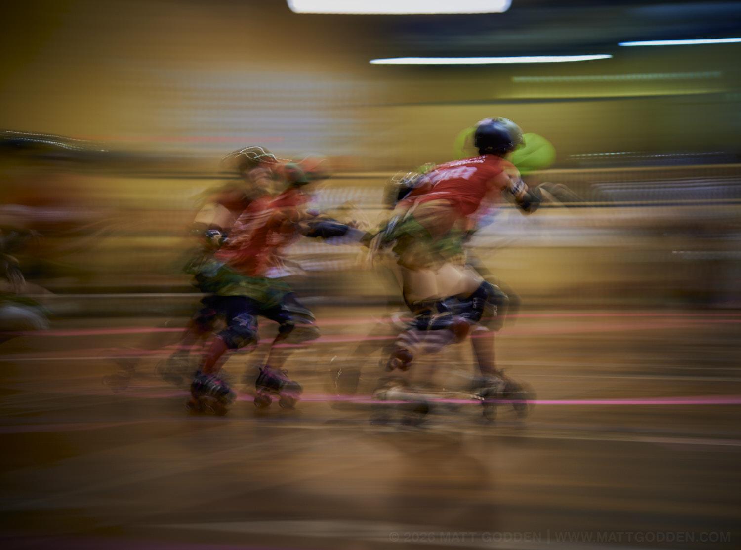A long exposure image of roller derby competitors from the D'Viants (lime green), and the Screaming Assault Sirens (red). 2013/11/09