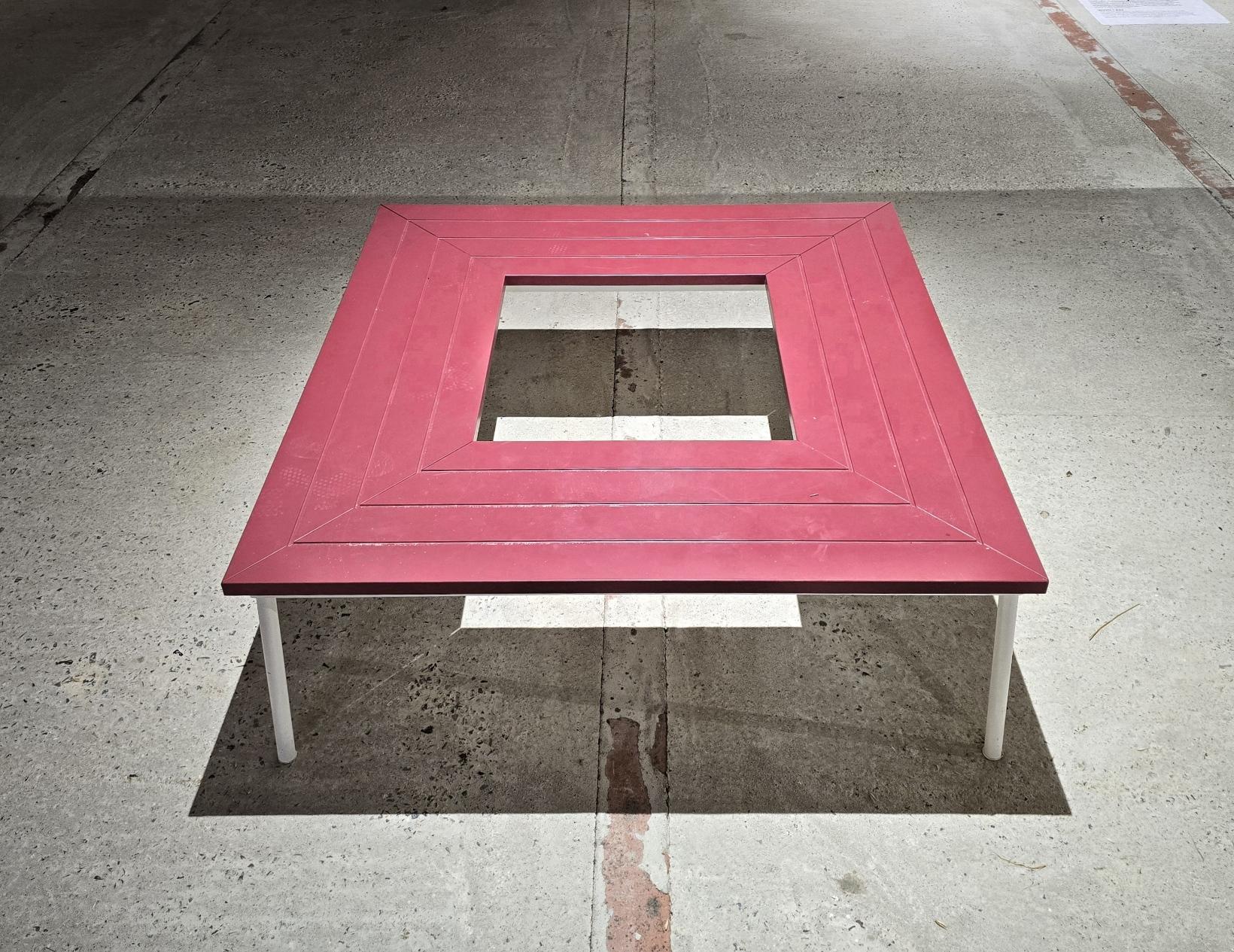 In Farbe. Sitzbank quadratisch. Durch das harte Licht sind klare Linien und Schatten zu sehen.