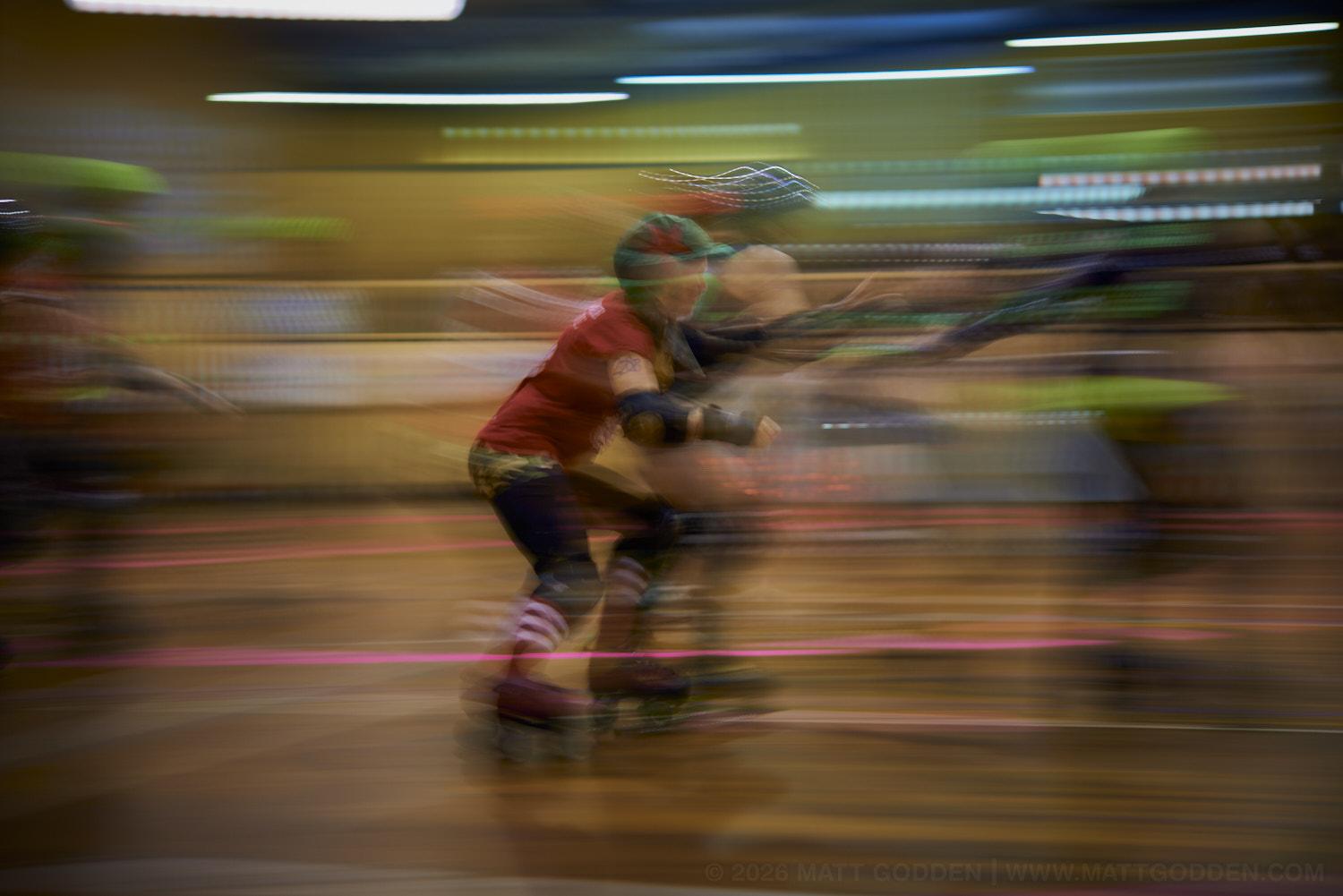 A long exposure image of roller derby competitors from the D'Viants (lime green), and the Screaming Assault Sirens (red). 2013/11/09