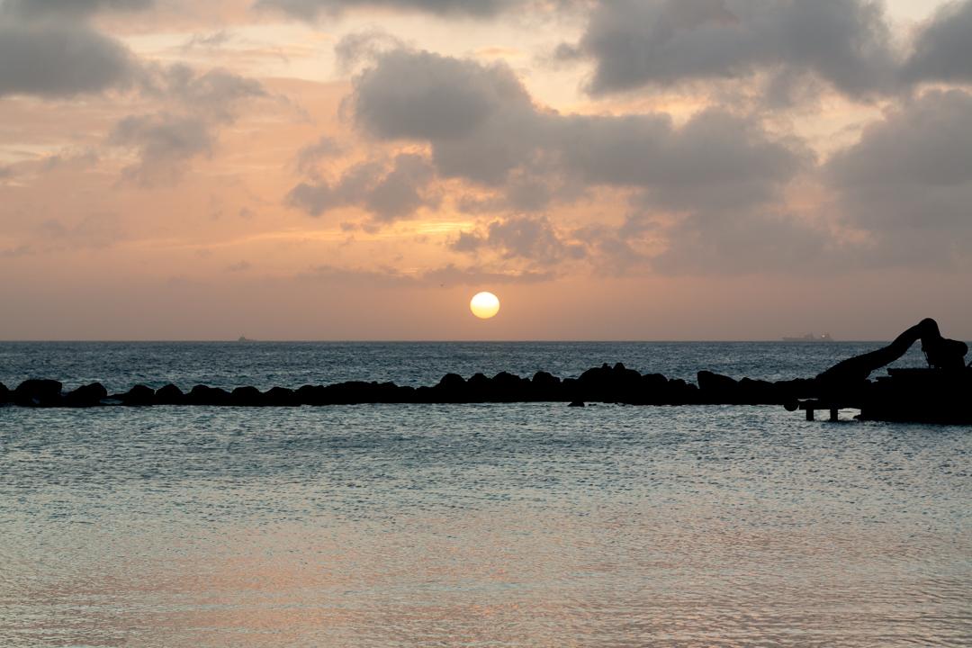 Last Light, Aruba — the sun sinking behind a bank of gold and gray clouds over the Caribbean Sea, a rock breakwater and retired dredge resting in silhouette below.

New fine art print, now available in metal, acrylic, canvas, and paper.

#FineArt #Aruba #Photography #Caribbean #Sunset