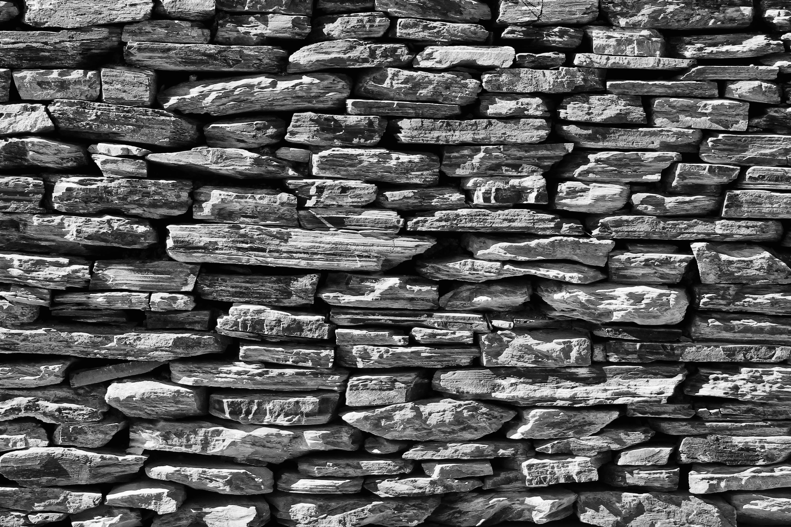 Schwarzweiss-Foto einer Mauer aus gelegten Natursteinen (ohne Mörtel)