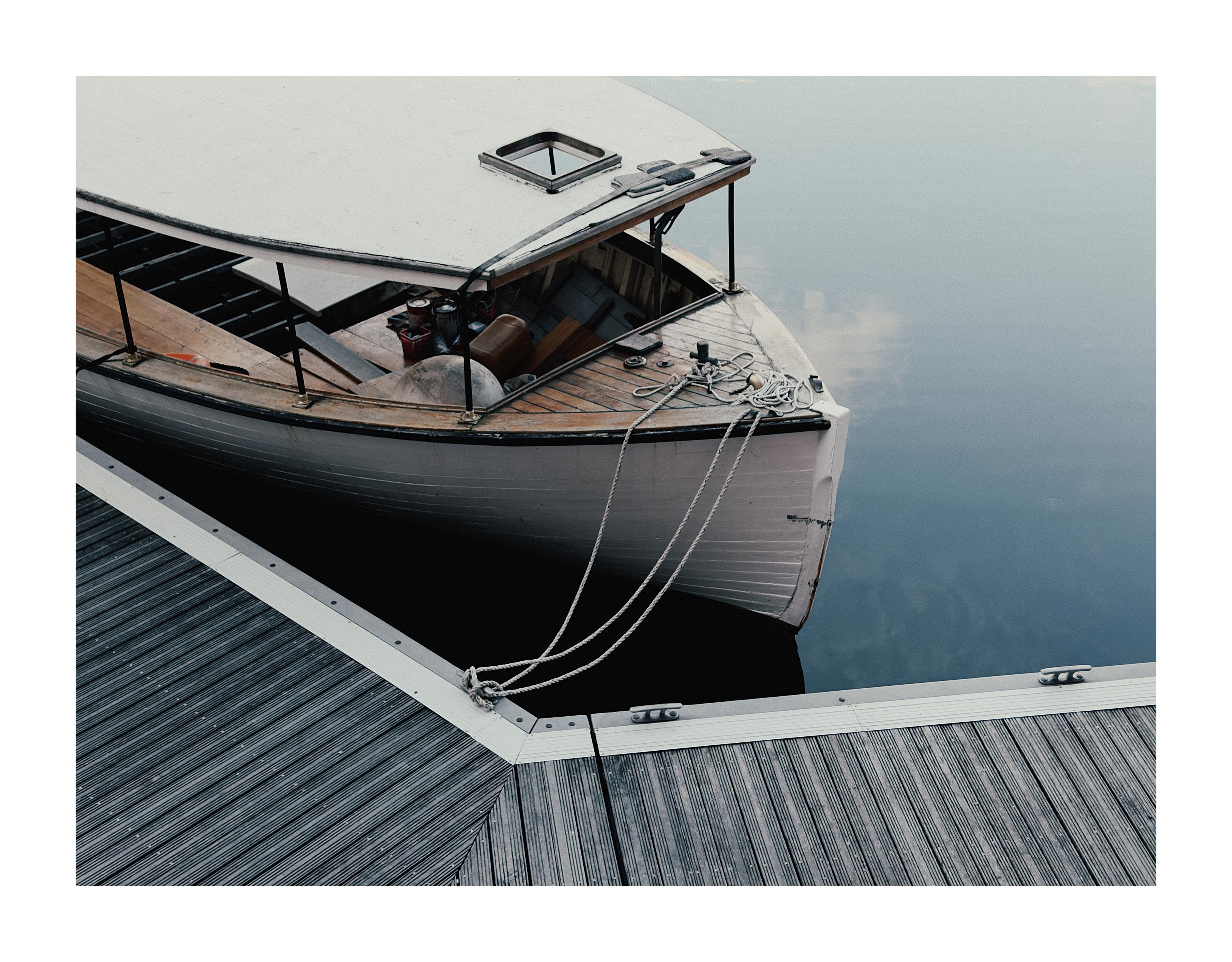 The front section of a boat moored at Albert Dock in Liverpool wiith still, calm water.
