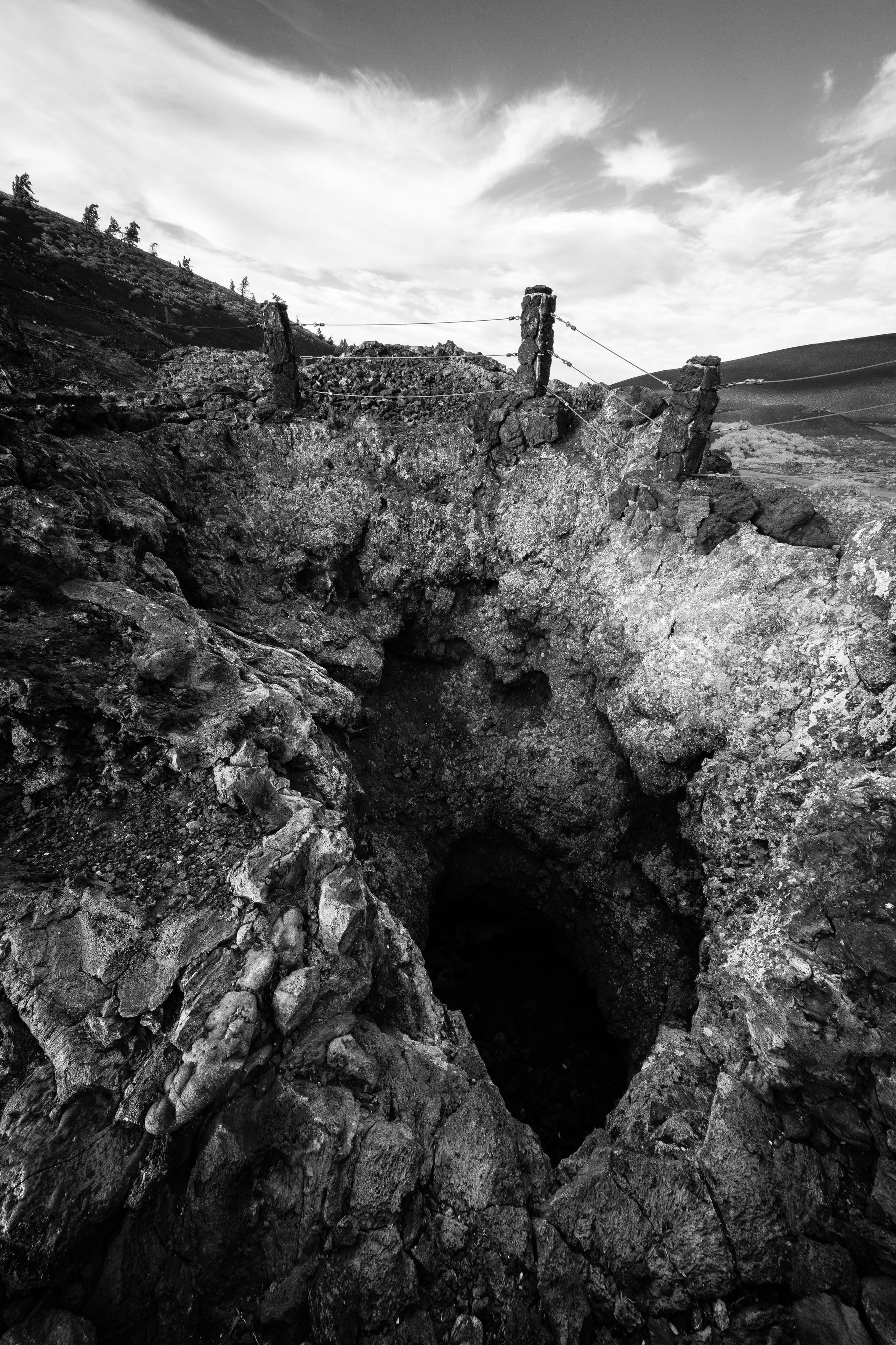 The opening of a spatter cone at Craters of the Moon. A fence is on the rim of the cone.