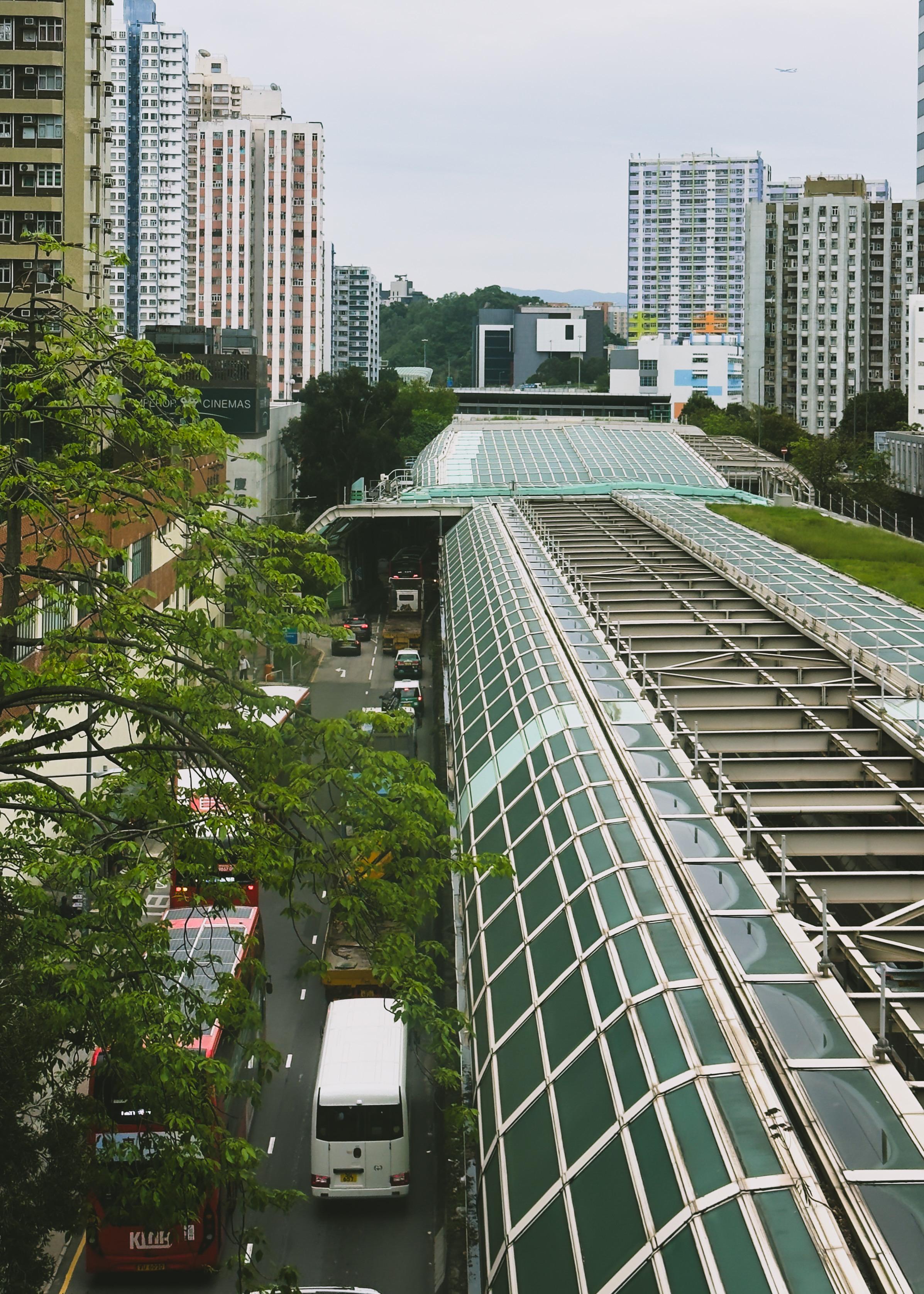 高楼林立，繁忙的城市道路上有公共汽车和私家车通行。
