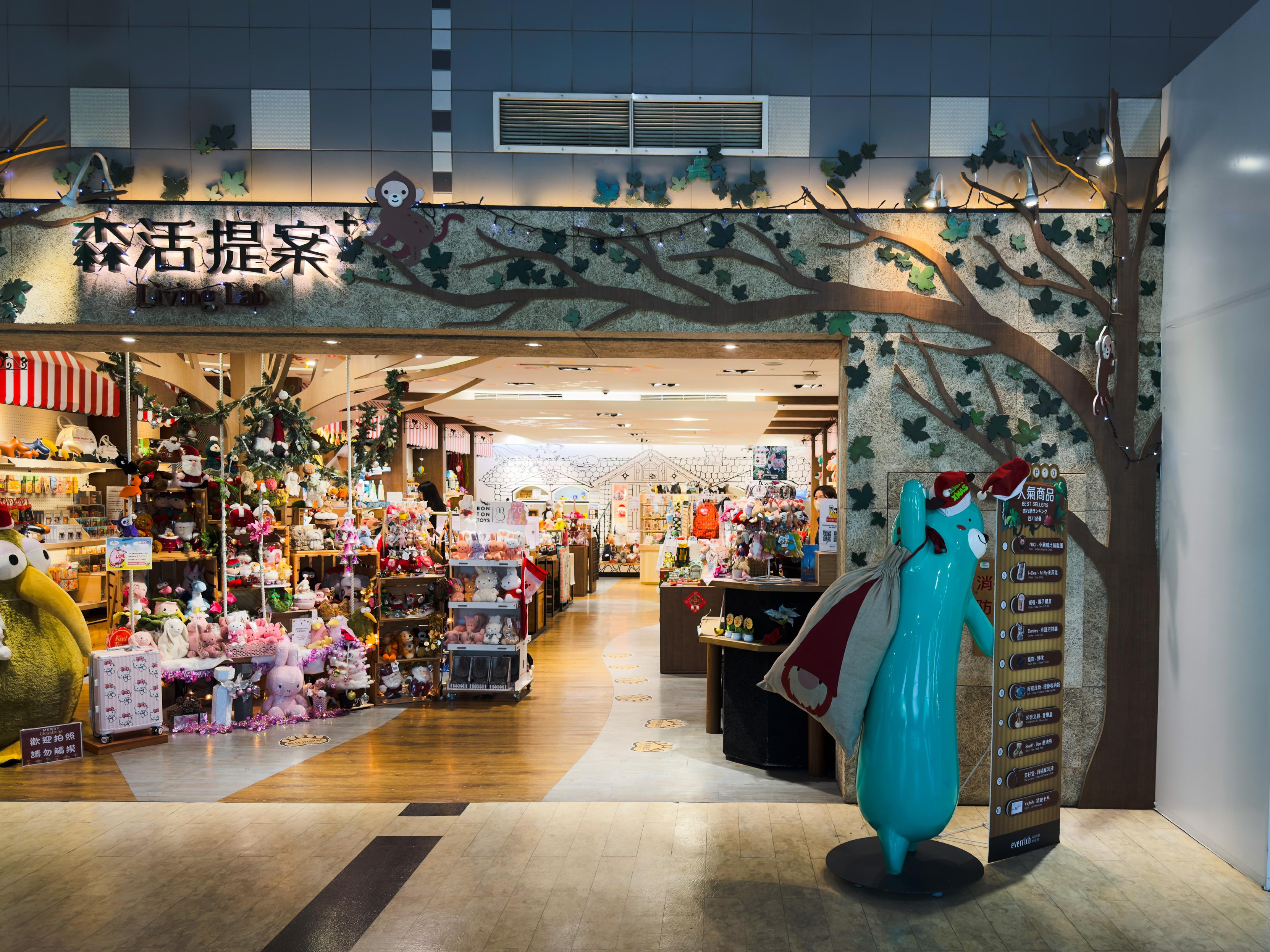 室内玩具店入口，装饰有树枝和猴子图案，货架上摆满各种毛绒玩具和礼品，环境温馨色彩丰富。