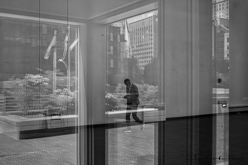 A man seen through multiple layers of glass, creating a hazy, ethereal image.