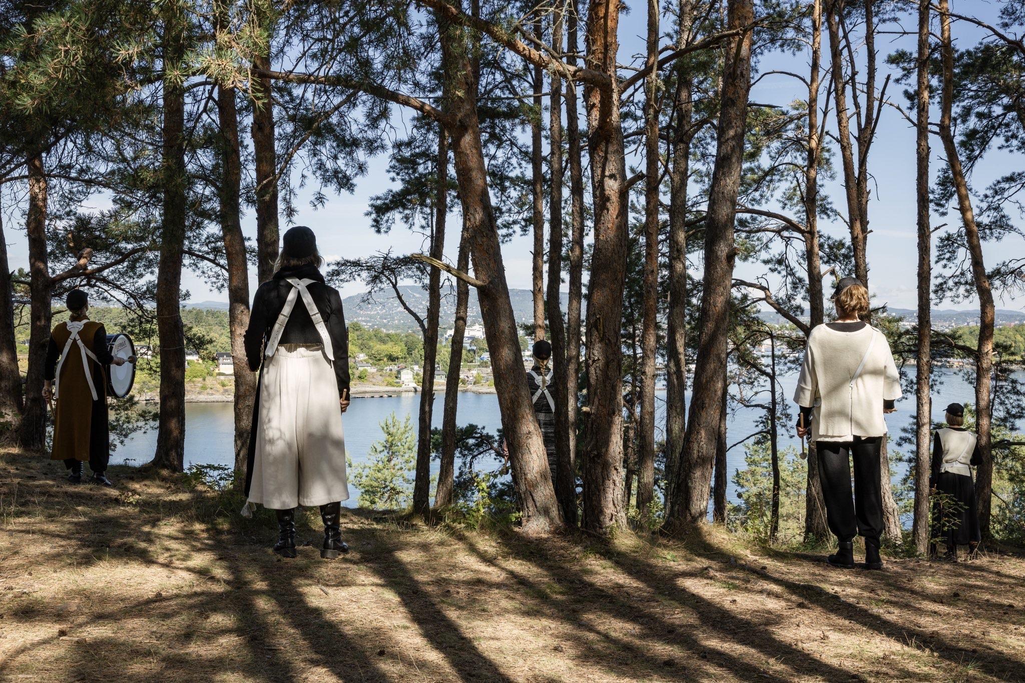 Dancers with marching drums performing in a forest.