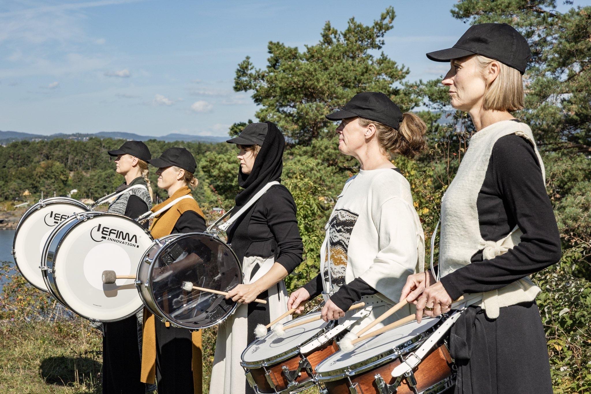 Dancers with marching drums performing in a forest.