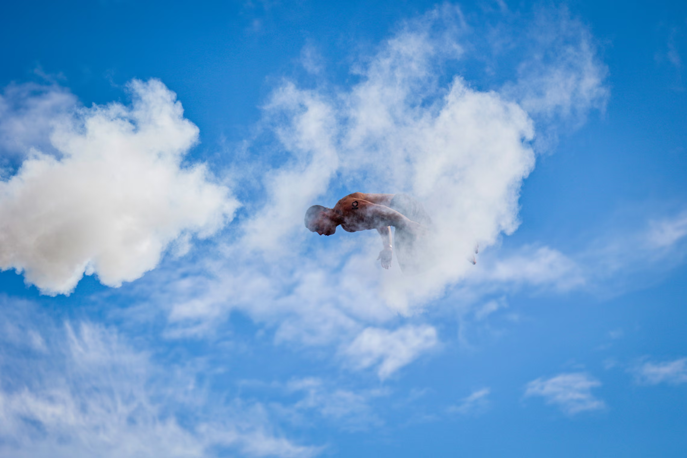 A diver appears to emerge from a cloud.