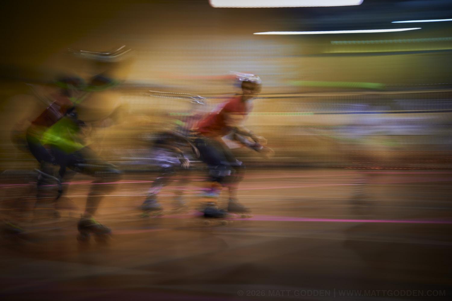 A long exposure image of roller derby competitors from the D'Viants (lime green), and the Screaming Assault Sirens (red). 2013/11/09