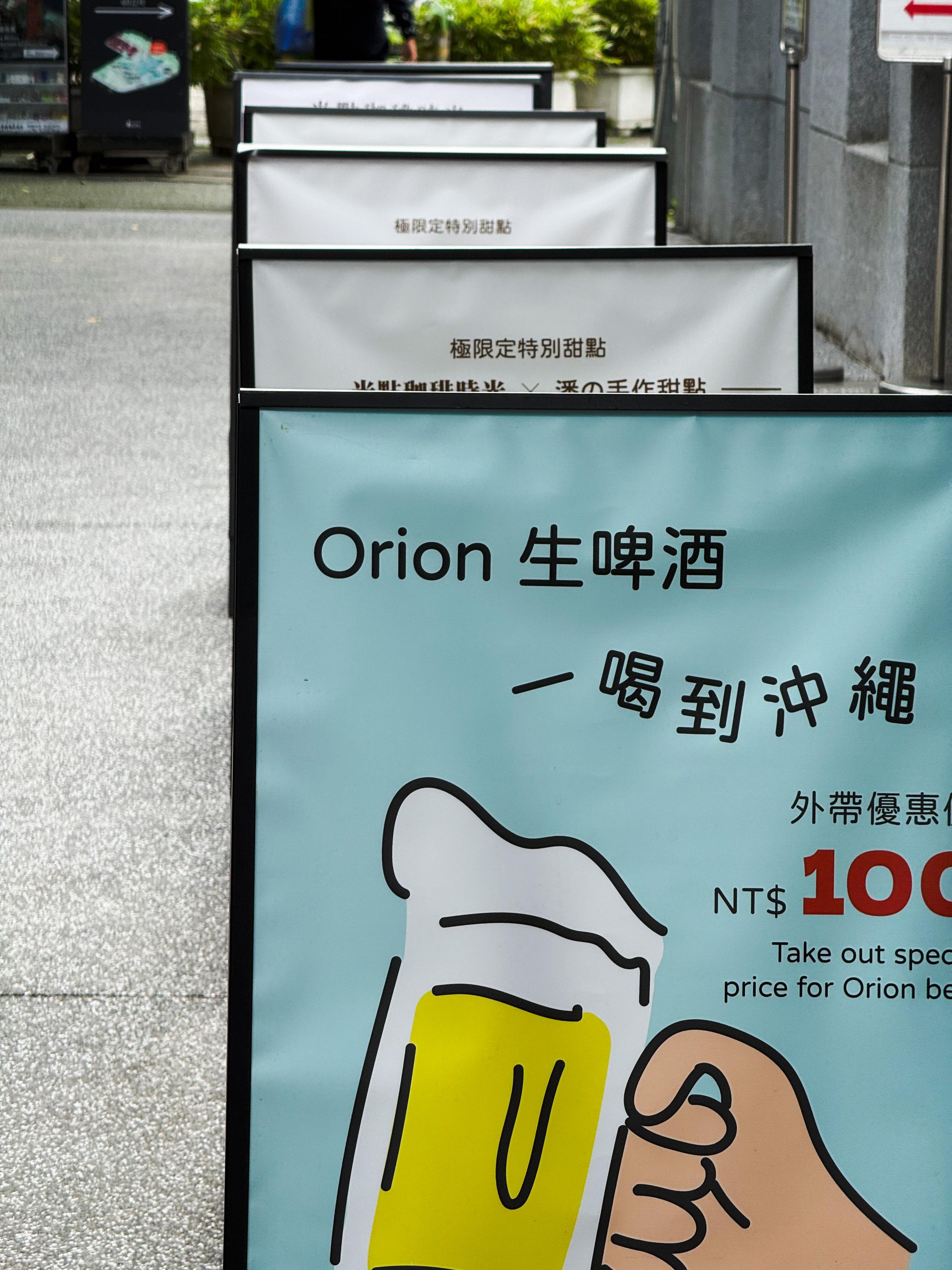 宣传牌显示“Orion 生啤酒，一喝到冲绳，外带优惠价NT$100”。