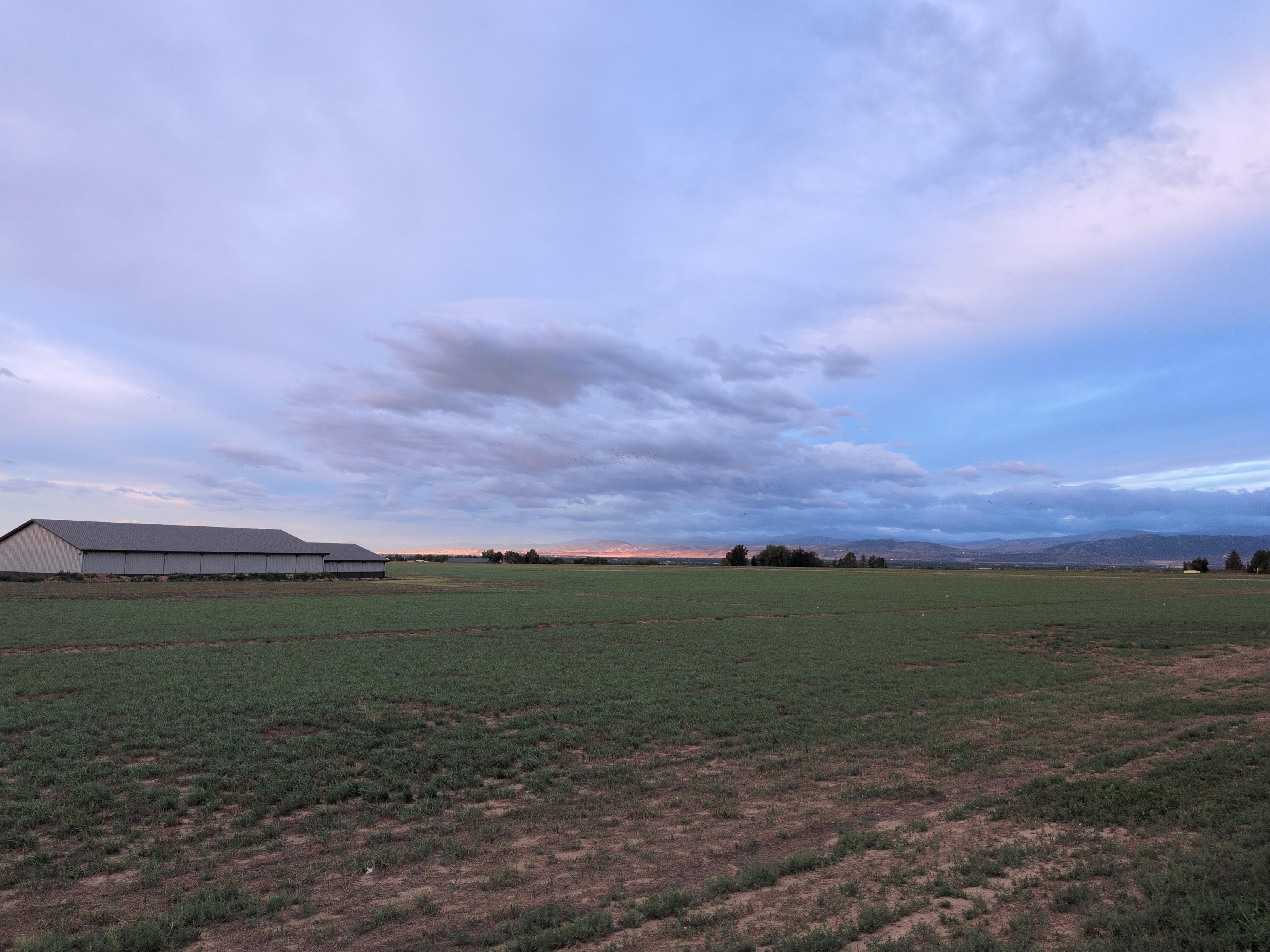 The barn from the previous photo from a different angle, a bit farther west. The same valley gazes upon a wash of bright morning sunlight flooding the front range in the distance, maybe ten or twelve miles away.