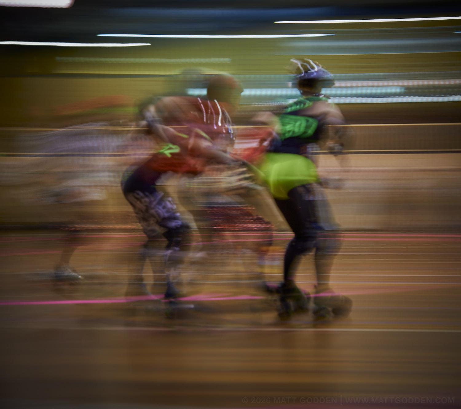 A long exposure image of roller derby competitors from the D'Viants (lime green), and the Screaming Assault Sirens (red). 2013/11/09
