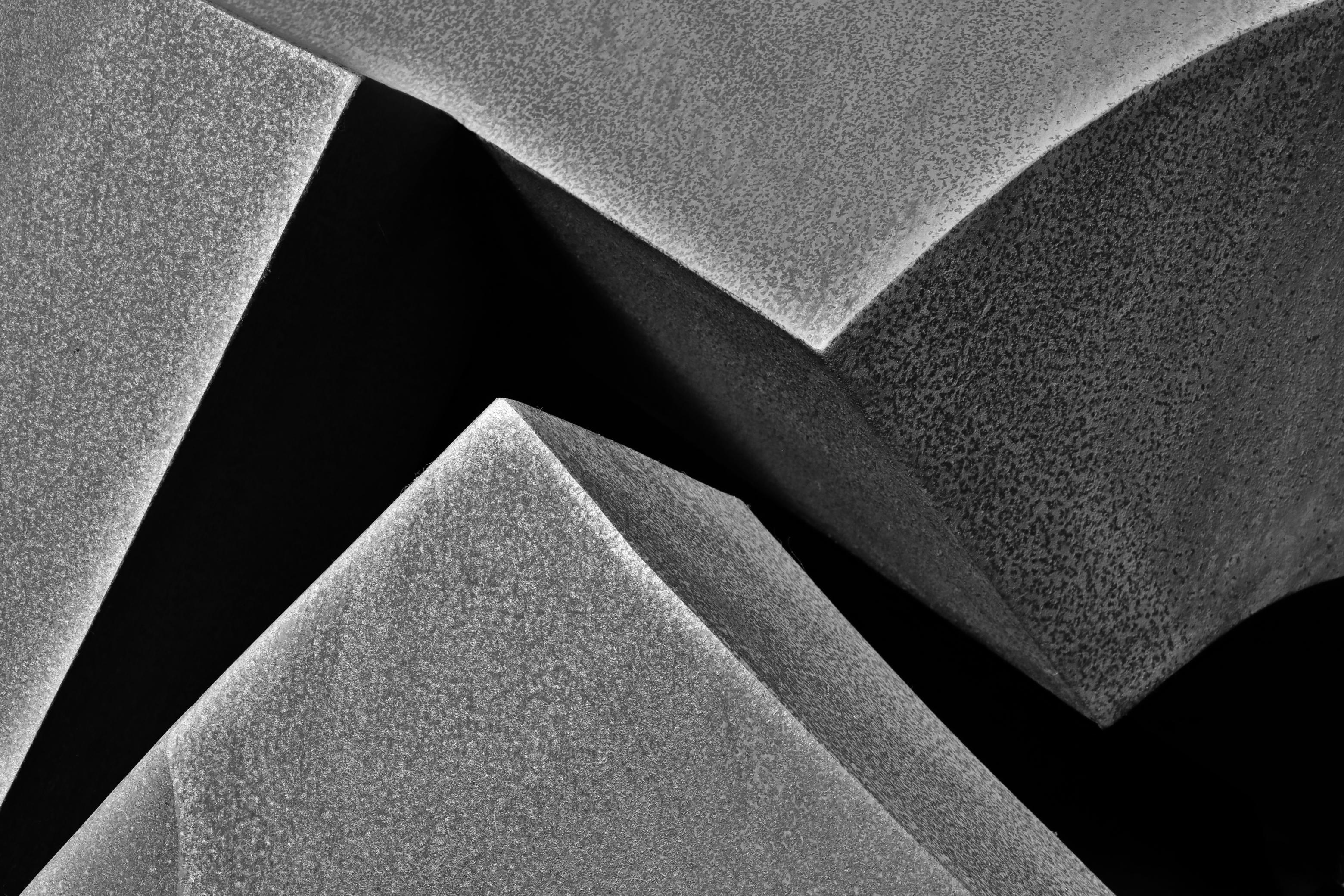 Schwarzweiss-Foto eines Ausschnittes von einer Skulptur aus rostigem Metall.
