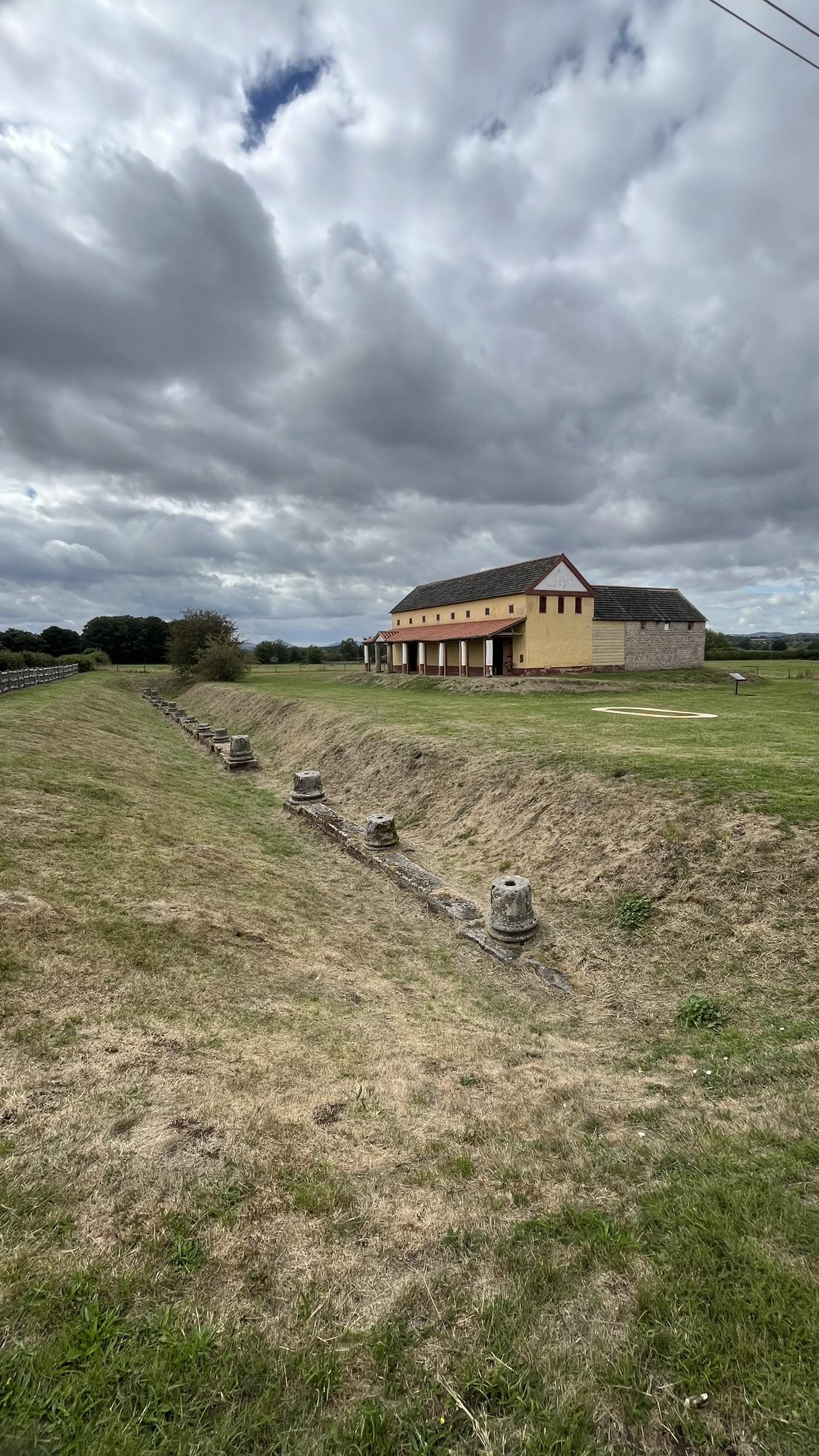 A picture of a replica Roman house, with the remains of columns in front of it.