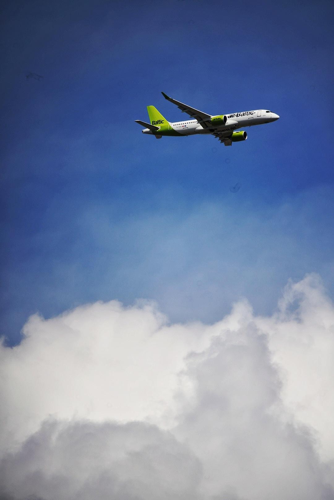 Flugzeug vor Himmel mit einigen Wolken