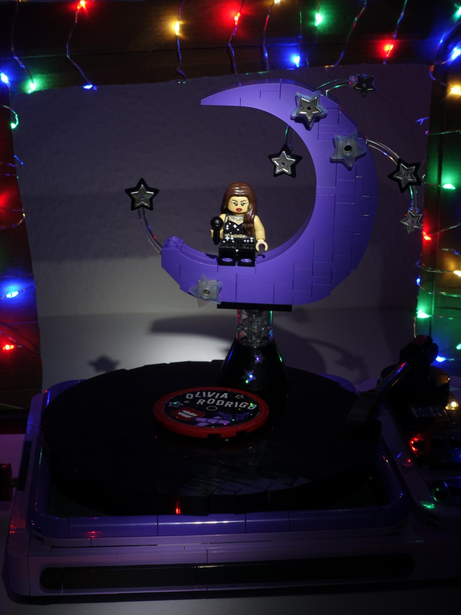 Olivia Rodrigo's Concert Moon Lego set in colorful lighting, with a spotlight on the minifigure of Olivia.