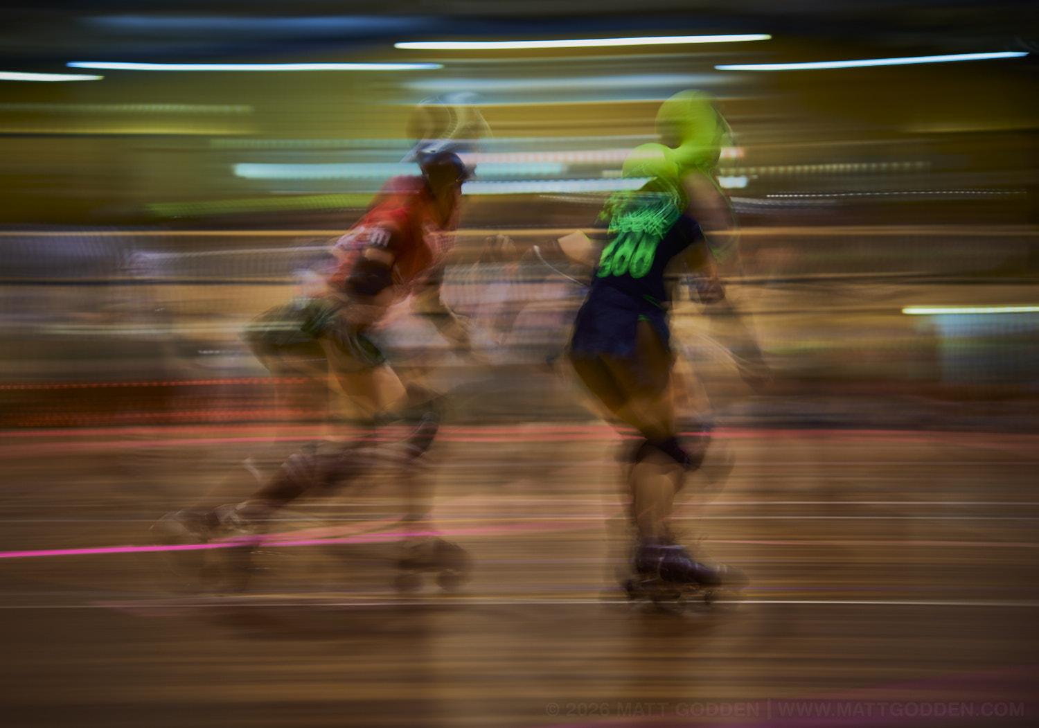 A long exposure image of roller derby competitors from the D'Viants (lime green), and the Screaming Assault Sirens (red). 2013/11/09