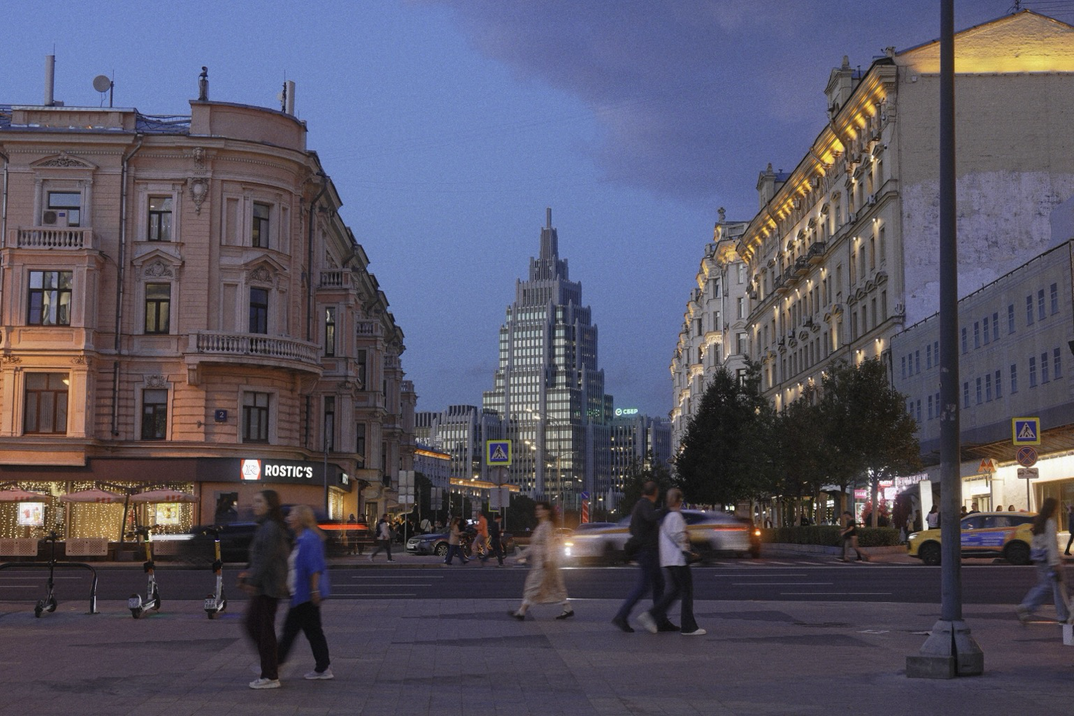 Вечерняя улица в центре Москвы. На переднем плане — пешеходы и машины в движении, по обеим сторонам исторические здания с подсветкой, вдали между ними возвышается сталинская высотка на фоне синего сумеречного неба.