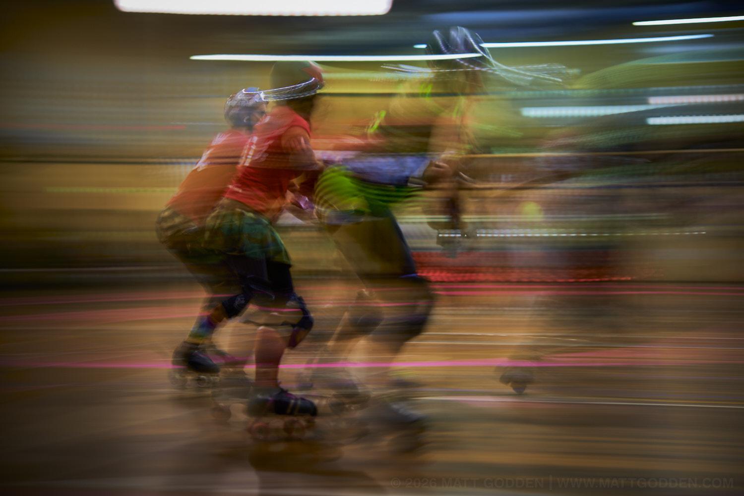A long exposure image of roller derby competitors from the D'Viants (lime green), and the Screaming Assault Sirens (red). 2013/11/09